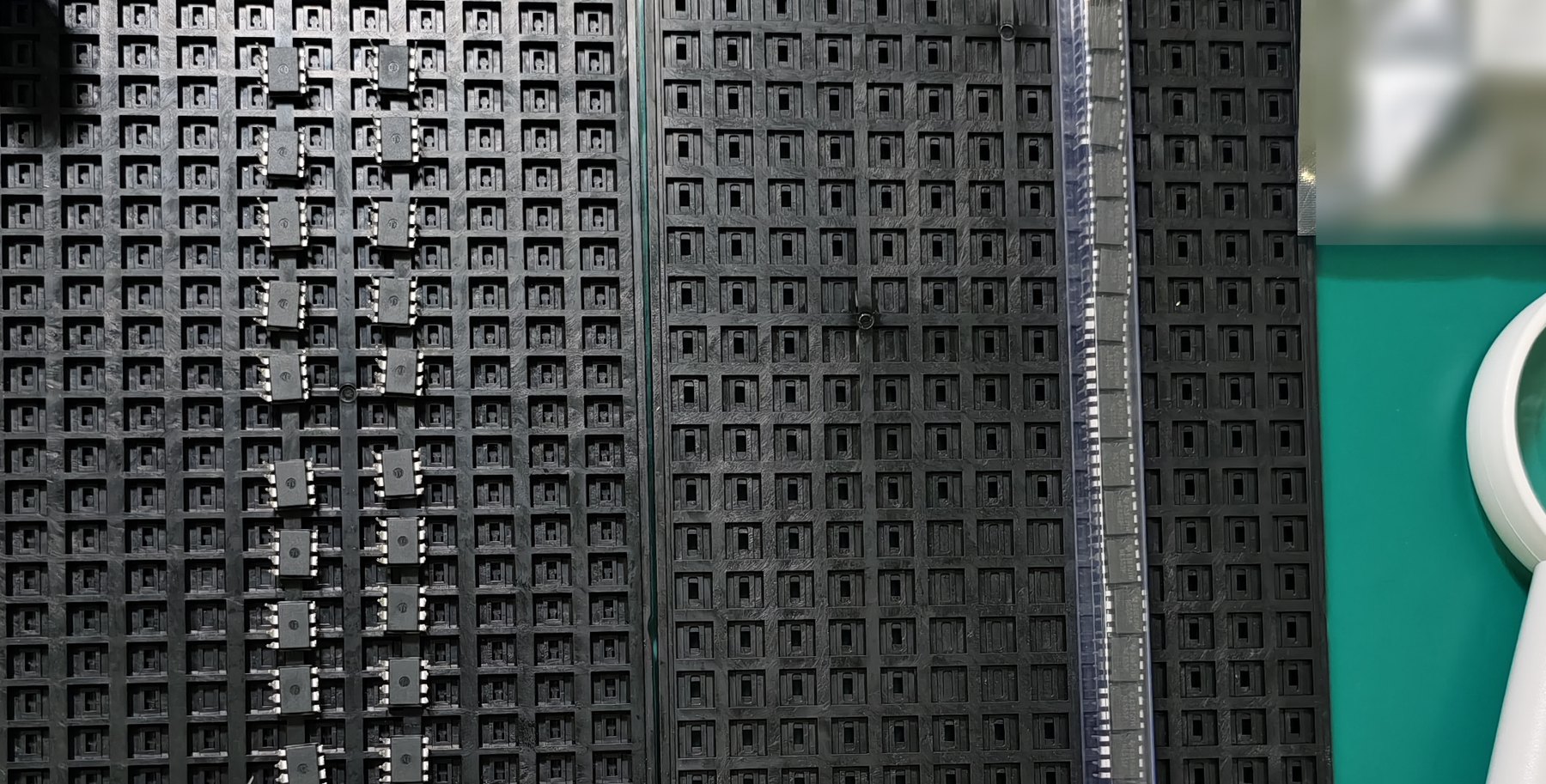 Received components in a waffle tray beside an anti-static tube on the receiving bench, waiting for package-form and quantity checks.